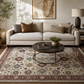 Living room with a beige sofa, round wooden coffee table, and patterned rug.