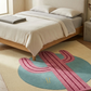 Bedroom with a colorful cactus-shaped rug on the floor.