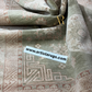 Close-up of a patterned rug with a visible brand label.