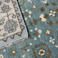 Close-up of two patterned rugs with floral designs on a light blue background.
