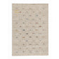 A rectangular woven area rug in a light beige color, featuring a grid pattern of small embroidered squares with various colorful geometric and tribal motifs.