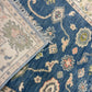 Close-up of two patterned rugs with intricate designs on a blue and beige background.