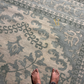 Patterned rug with feet at the bottom corner