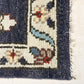 Close-up of a textured rug with floral patterns and fringe on a white background
