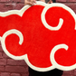 Person holding a large red cloud symbol against a brick wall