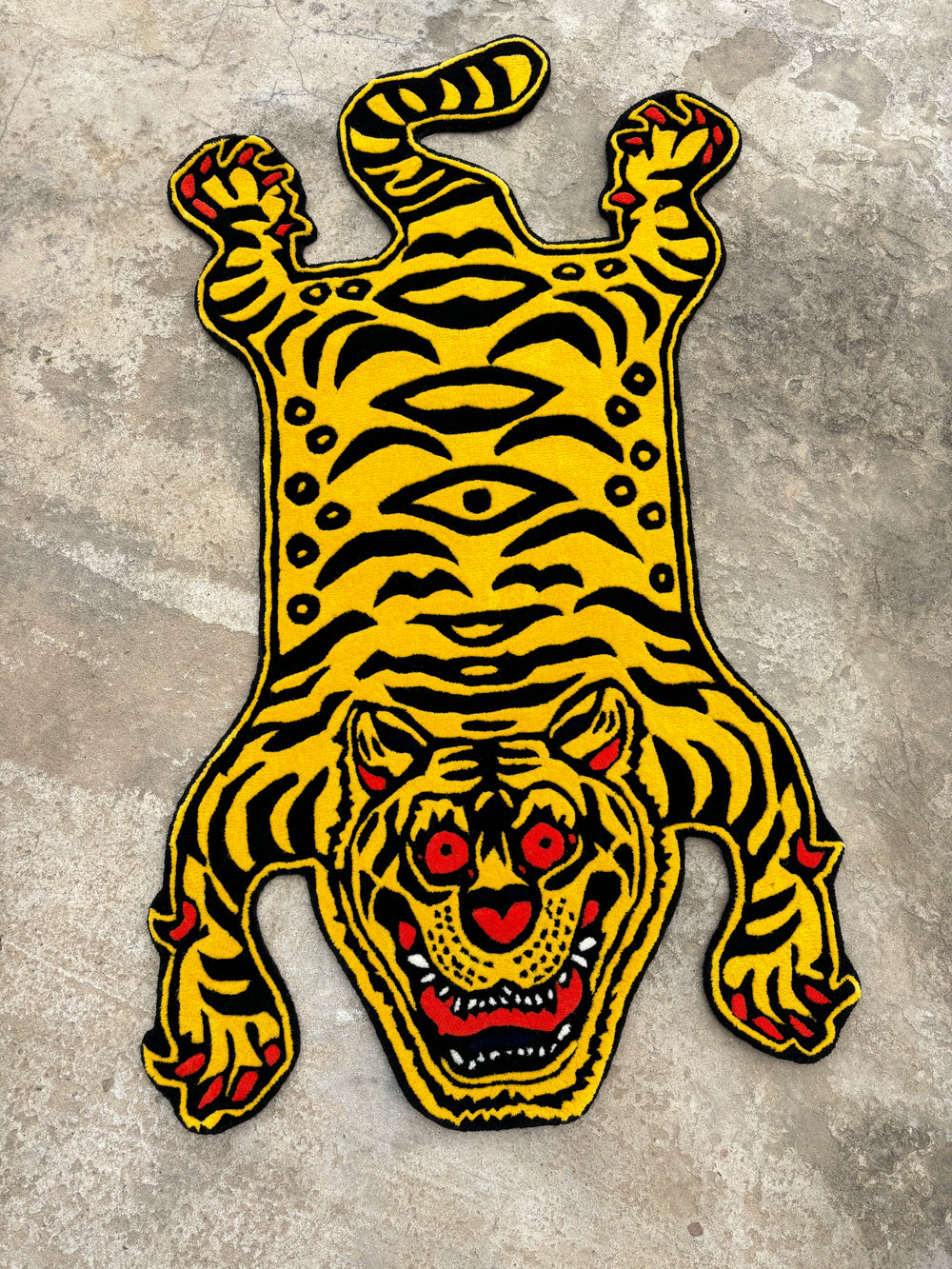 A vibrant yellow and black tiger rug with exaggerated features, designed for home decor.