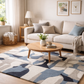 Living room with a beige sofa, wooden coffee table, and geometric-patterned rug.