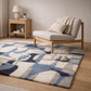 Living room with a patterned rug, wooden bench, and side table.