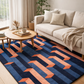 Living room with a blue and orange geometric rug, beige sofa, and wooden coffee table.