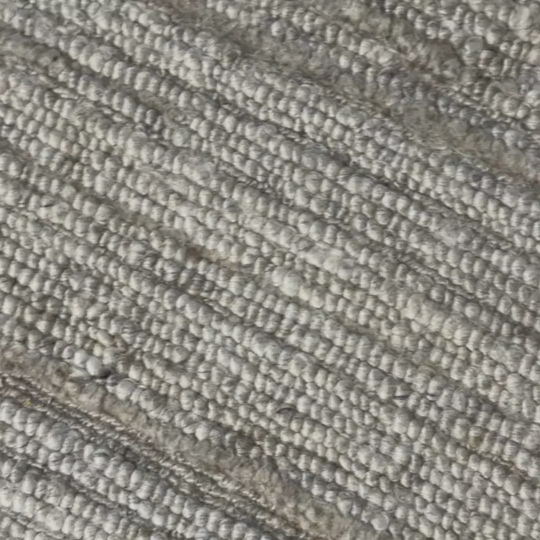 Close-up of a patterned rug with a visible textures.