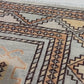 Close-up of a patterned rug with a visible textures.