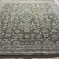 Close-up of a patterned rug with geometric designs in shades of brown, beige, and gray.