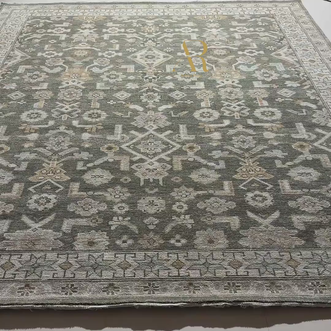 Close-up of a patterned rug with geometric designs in shades of brown, beige, and gray.