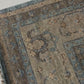 Close-up of a patterned rug with a visible textures.