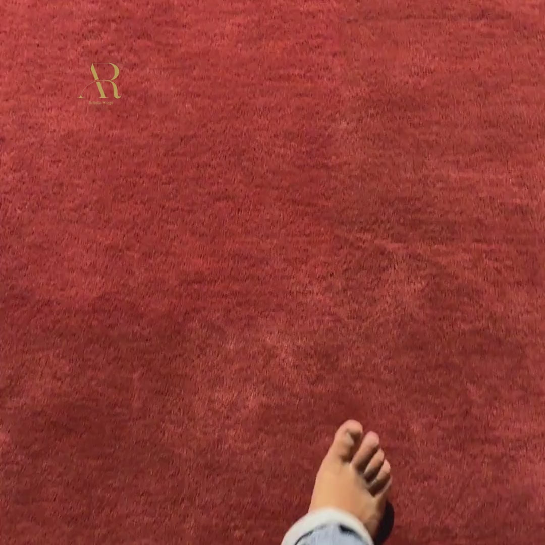 Red rug with a logo in a dimly lit room.