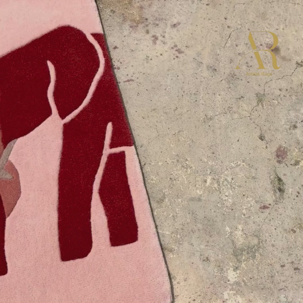 Pink towel with elephant design and 'AR' logo on a white background