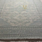Roll of patterned fabric with a brand logo on a dark surface