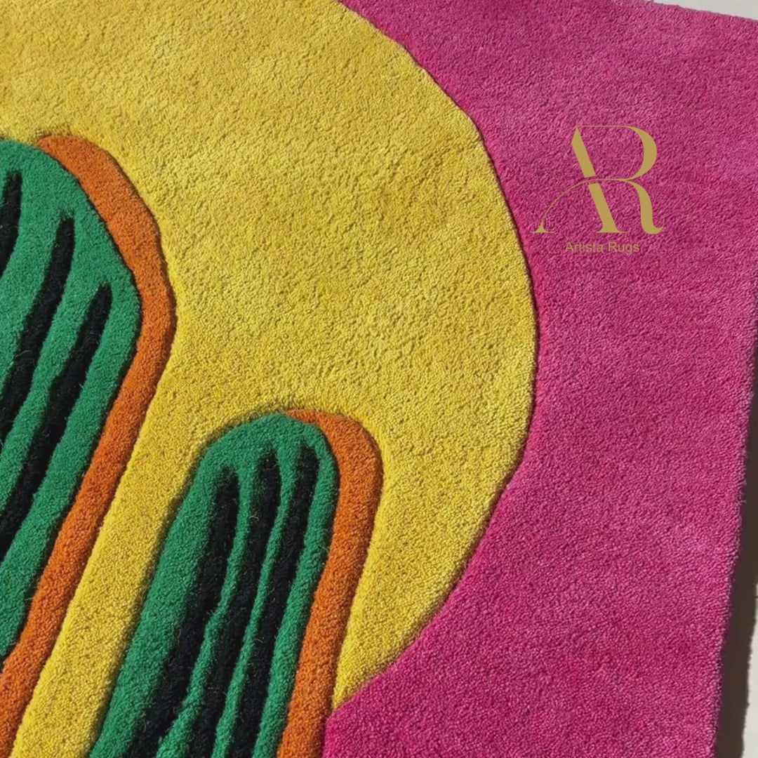 Rug with a green cactus and yellow sun design on a pink background