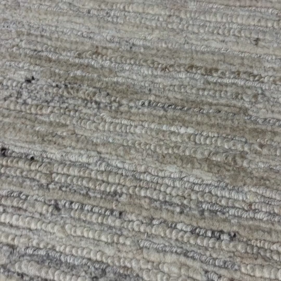Close-up of a patterned rug with a visible textures.