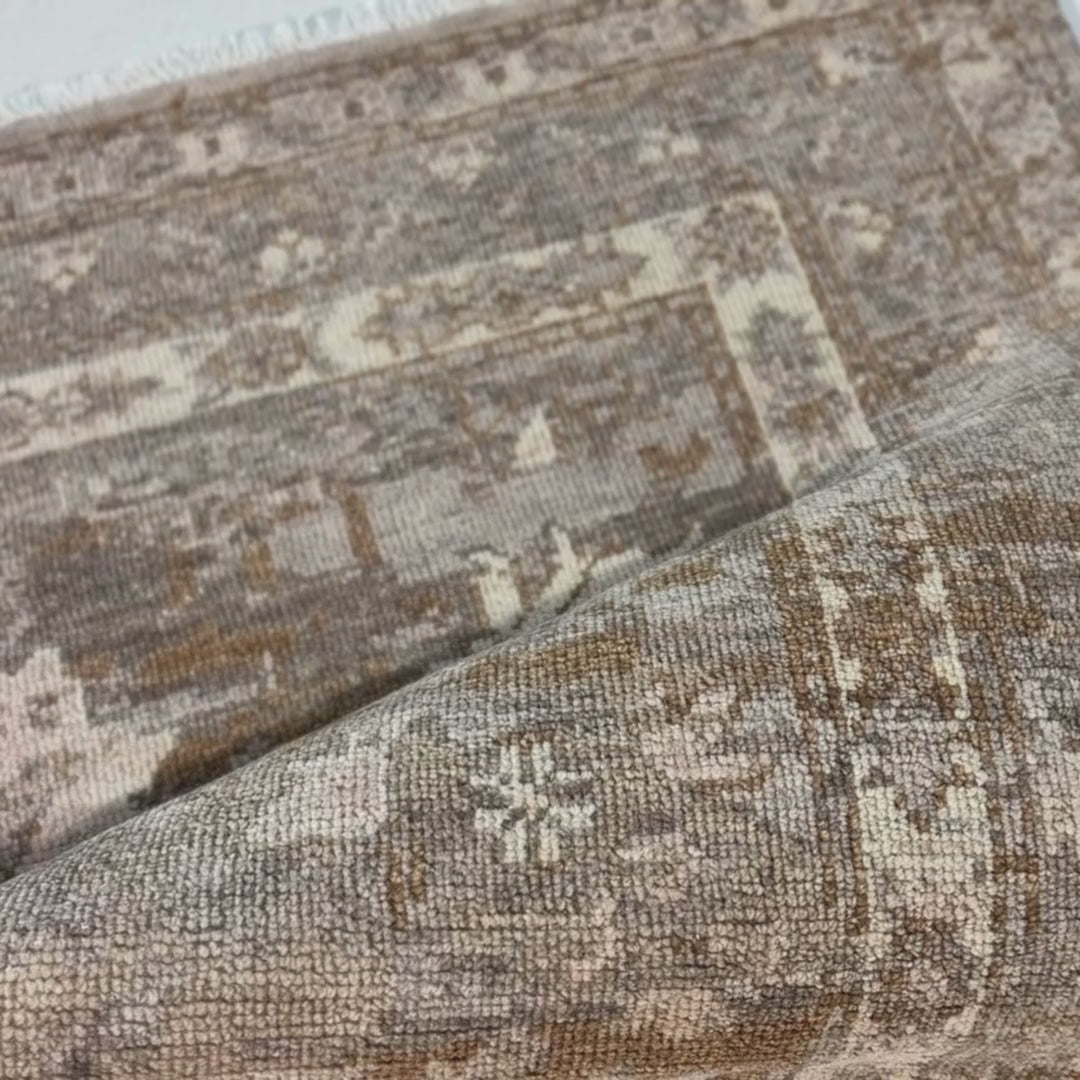 Close-up of a patterned rug with a visible textures.