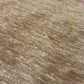 A rectangular brown area rug with a textured, heathered finish, featuring horizontal bands of small red geometric motifs and a central gold Om symbol near the bottom.