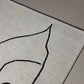 Rug with abstract line art of a face on a beige background