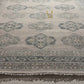 Textured fabric with intricate patterns in shades of gray and beige.