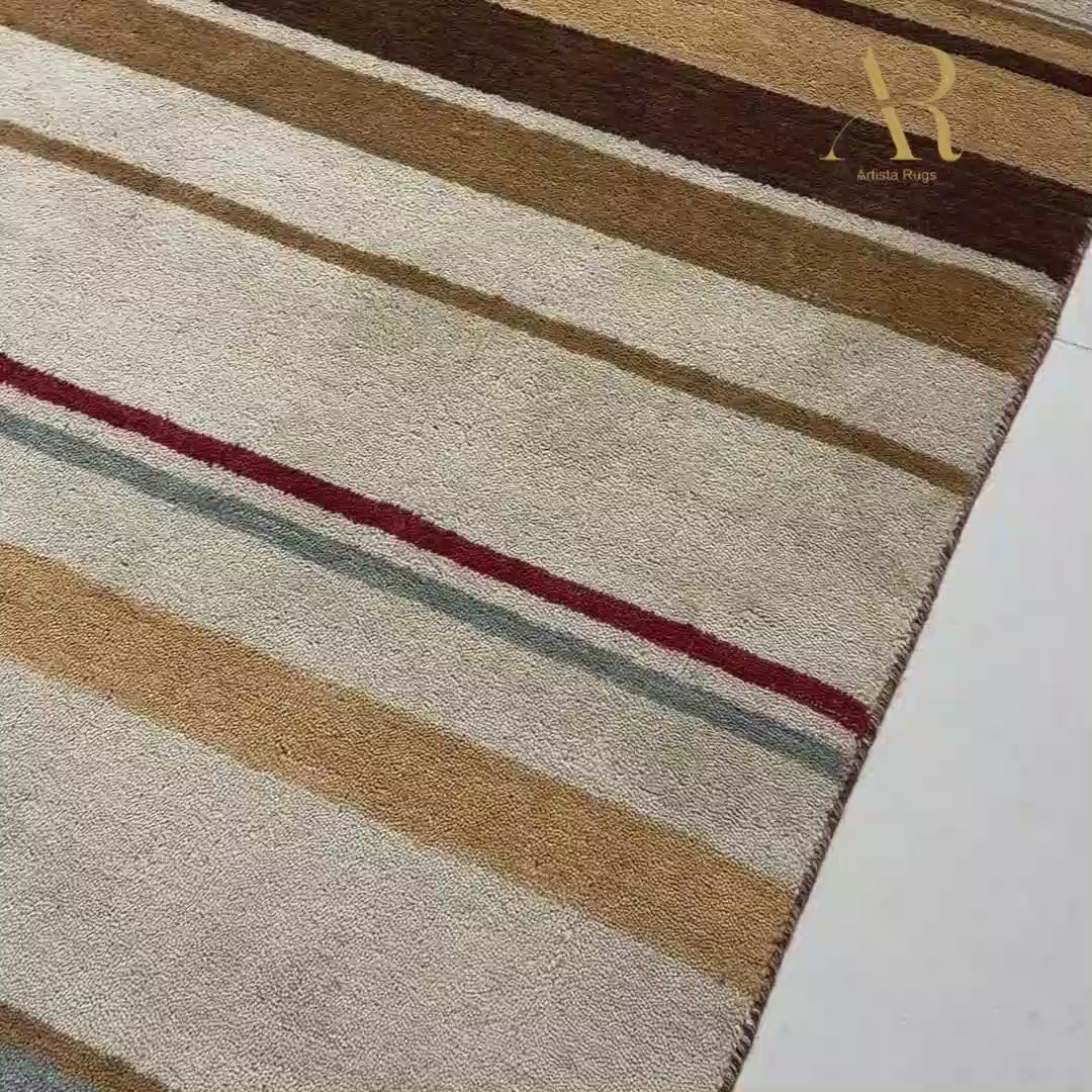 A rectangular area rug with vertical stripes in beige, brown, red, and light blue. 